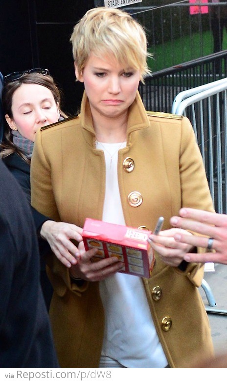 Jennifer Lawrence signing a box of Cheez-Its