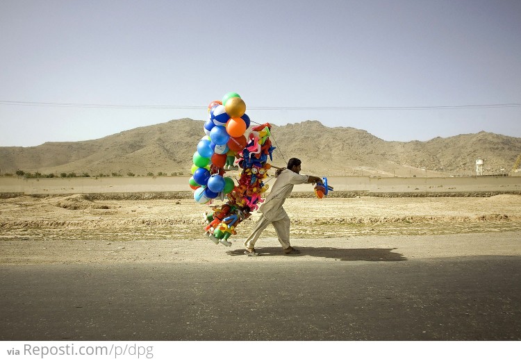 Afghan Man Carries Balloons Alongside A Road Near Kabul