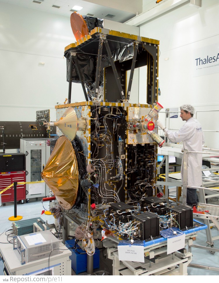 The Sentinel-3A satellite during integration at Thales Alenia Space in Cannes, France. The open side of the satellite reveals the Synthetic Aperture Radar Altimeter’s electronic units, while its antenna (covered by orange protective material) is mounted on the exterior panel – this side of the satellite will face Earth when the satellite is in orbit.