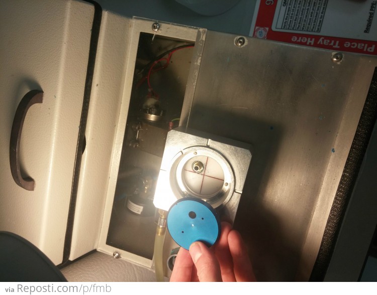 The block is placed on a wax blocker machine that has melted wax in the cente.  The silver square ring ish thing is full of antifreeze cycling through to chill the wax quickly after it is injected between the block and the lens