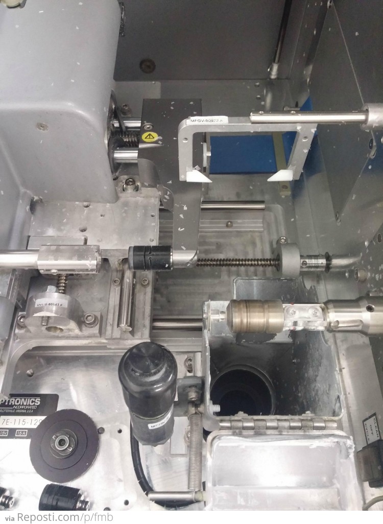 THIS is the edger.  The pads on the left chuck the lens in place using the block that we just attached.  The blade is on the right.  The probes are made of very soft wax so as not to scratch the lens when checking thickness.