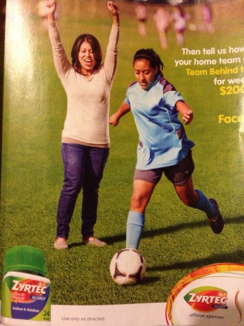 Why is she standing in the middle of the soccer field?